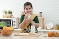 Little cute Indian kid girl smiling and holding a glass of milk for breakfast with bread, jam, crackers and fruits in kitchen Royalty Free Stock Photo