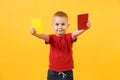 Little cute kid baby boy in red t-shirt holding in hand yellow and red soccer referee cards for retire from field
