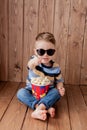 Little cute kid baby boy 2-3 years old , 3d cinema glasses holding bucket for popcorn, eating fast food on wooden background. Kids Royalty Free Stock Photo