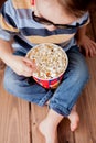 Little cute kid baby boy 2-3 years old , 3d cinema glasses holding bucket for popcorn, eating fast food on wooden background. Kids Royalty Free Stock Photo