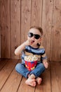 Little cute kid baby boy 2-3 years old , 3d cinema glasses holding bucket for popcorn, eating fast food on wooden background. Kids Royalty Free Stock Photo