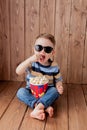 Little cute kid baby boy 2-3 years old , 3d imax cinema glasses holding bucket for popcorn, eating fast food on wooden background Royalty Free Stock Photo