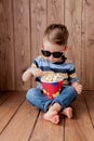 Little cute kid baby boy 2-3 years old , 3d imax cinema glasses holding bucket for popcorn, eating fast food on wooden background Royalty Free Stock Photo