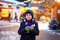 Little cute kid boy drinking hot children punch or chocolate on German Christmas market. Happy child on traditional Royalty Free Stock Photo