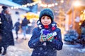 Little cute kid boy drinking hot children punch or chocolate on German Christmas market. Happy child on traditional Royalty Free Stock Photo