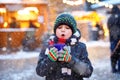 Little cute kid boy drinking hot children punch or chocolate on German Christmas market. Happy child on traditional Royalty Free Stock Photo