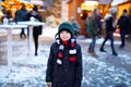 Little cute kid boy having fun on German Christmas market. Happy child on traditional family market in Germany, Laughing Royalty Free Stock Photo