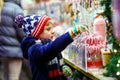 Little kid boy with candy cane stand on Christmas market Royalty Free Stock Photo