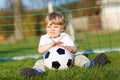 Little cute kid boy of 4 playing soccer with football on field, outdoors Royalty Free Stock Photo