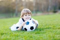 Little cute kid boy of 4 playing soccer with football on field, outdoors Royalty Free Stock Photo