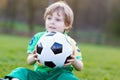 Little cute kid boy of 4 playing soccer with football on field, outdoors Royalty Free Stock Photo