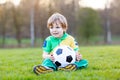 Little cute kid boy of 4 playing soccer with football on field, outdoors Royalty Free Stock Photo