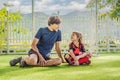 Little cute kid boy in red football uniform and his trainer or father playing soccer, football on field, outdoors Royalty Free Stock Photo