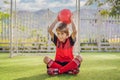 Little cute kid boy in red football uniform playing soccer, football on field, outdoors. Active child making sports with Royalty Free Stock Photo