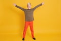 Little cute kid boy wearing casual clothes isolated over yellow wall background, children studio portrait. People sincere emotions