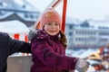 Little cute kid girl having fun on ferris wheel on traditional German Christmas market during strong snowfall.