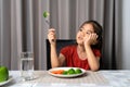 Little cute kid girl refusing to eat healthy vegetables. Children do not like to eat vegetables Royalty Free Stock Photo