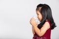 Little cute kid girl 3-4 years old smile drinking fresh water from glass in studio shot isolated Royalty Free Stock Photo