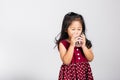 Little cute kid girl 3-4 years old smile drinking fresh water from glass in studio shot isolated Royalty Free Stock Photo