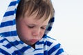 Little cute kid hurt and pouted, disappointed. Beautiful little kid with atopic dermatitis on the background of the sea, Royalty Free Stock Photo