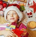 Little cute kid in santas red hat with handmade gifts, toys vintage wooden, warm winter Royalty Free Stock Photo