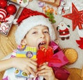 Little cute kid in santas red hat with handmade gifts, toys vintage wooden, warm winter Royalty Free Stock Photo