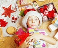 Little cute kid in santas red hat with handmade gifts, toys vintage wooden, warm winter, lifestyle people concept Royalty Free Stock Photo