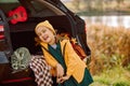 Little cute laughing girl standing near by on open car trunk. Kid resting with her family in the nature. Autumn season Royalty Free Stock Photo