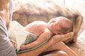 Little cute newborn girl wearing a diaper sleeping on mother lap Royalty Free Stock Photo