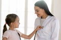 Little cute patient wearing phonendoscope, listening heartbeat of nurse.