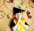 Little cute preschooler boy among toys lego at home education in graduate hat smiling posing emotional, lifestyle people Royalty Free Stock Photo