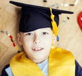 Little cute preschooler boy among toys lego at home in graduate hat smiling posing emotional, lifestyle people concept Royalty Free Stock Photo