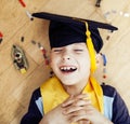 Little cute preschooler boy among toys lego at home in graduate hat smiling posing emotional, lifestyle people concept Royalty Free Stock Photo