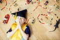Little cute preschooler boy among toys lego at home in graduate hat smiling posing emotional, lifestyle people concept Royalty Free Stock Photo