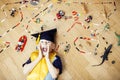 Little cute preschooler boy among toys lego at home in graduate hat smiling posing emotional, lifestyle people concept Royalty Free Stock Photo