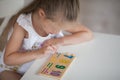 Little cute preschooler child girl playing educational games with wooden mathematical multicolored figures preparing for