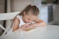 Little cute preschooler child girl playing educational games with wooden mathematical multicolored figures preparing for school in