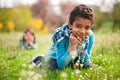 Little cute real black boy smiling and siting in a flower field Royalty Free Stock Photo