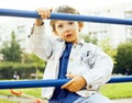 Little cute boy playing on playground, hanging on gymnastic ring Royalty Free Stock Photo