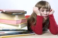 Little cute sad girl with a pile of book sitting