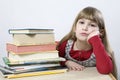 Little cute sad girl with a pile of book sitting Royalty Free Stock Photo