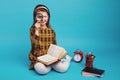 Little cute schoolgirl in checkered dress holding magnifier and smiling Royalty Free Stock Photo