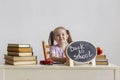 Little cute schoolgirl sits at her desk at school with textbooks.  Kid is learning in class. Back to school. Royalty Free Stock Photo