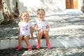 Little cute sisters sitting at street in old Greek Royalty Free Stock Photo