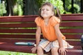 Little cute smiling girl with book on bench Royalty Free Stock Photo