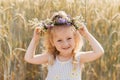 Little cute smiling girl with a wreath of flowers on her head in the summer in nature Royalty Free Stock Photo