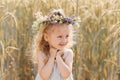 Little cute smiling girl with a wreath of flowers on her head in the summer in nature Royalty Free Stock Photo