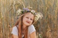 Little cute smiling girl with a wreath of flowers on her head in the summer in nature Royalty Free Stock Photo