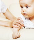 Little cute toddler baby boy playing on chair, mother insures holding hand, lifestyle people concept