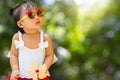 Little cute toddler baby girl wearing sun glasses on blurred green nature background Royalty Free Stock Photo